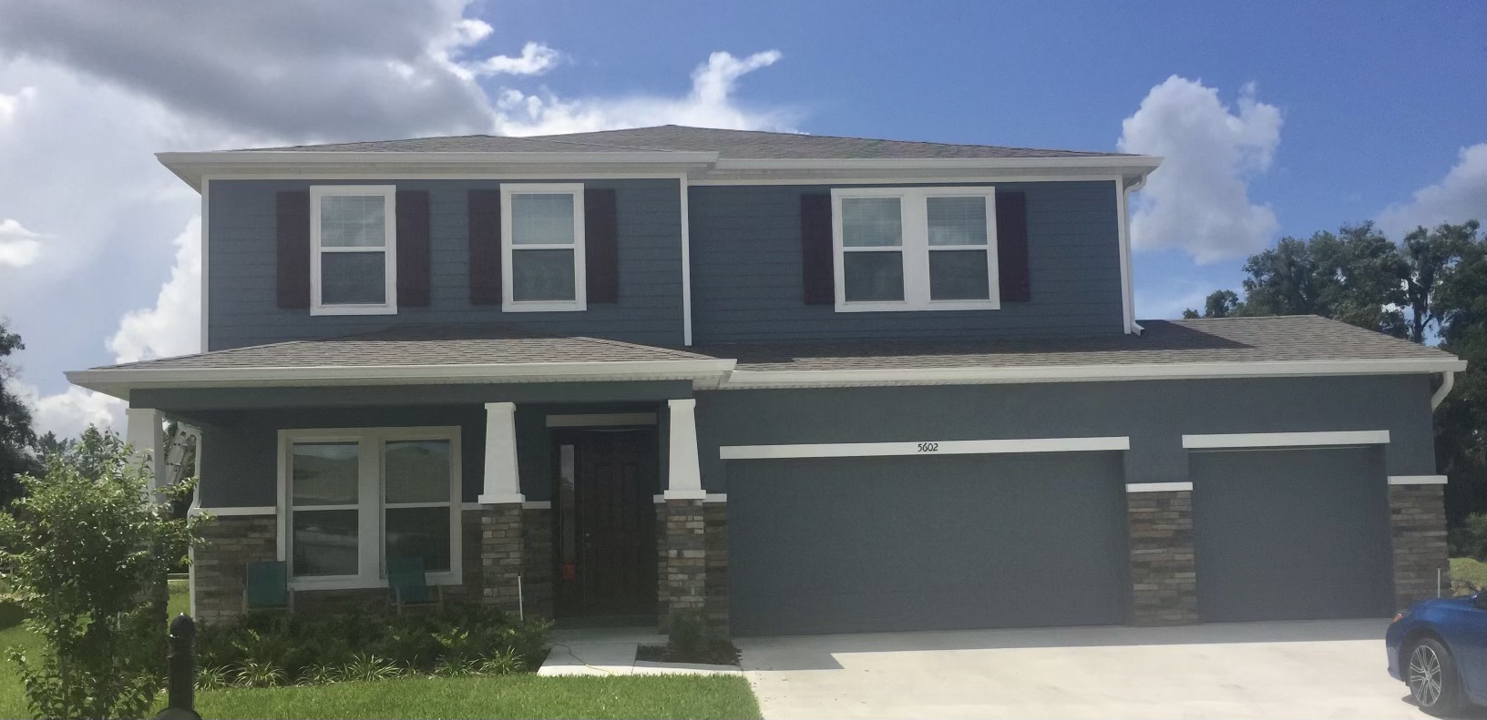 Two-story blue home with white seamless gutters