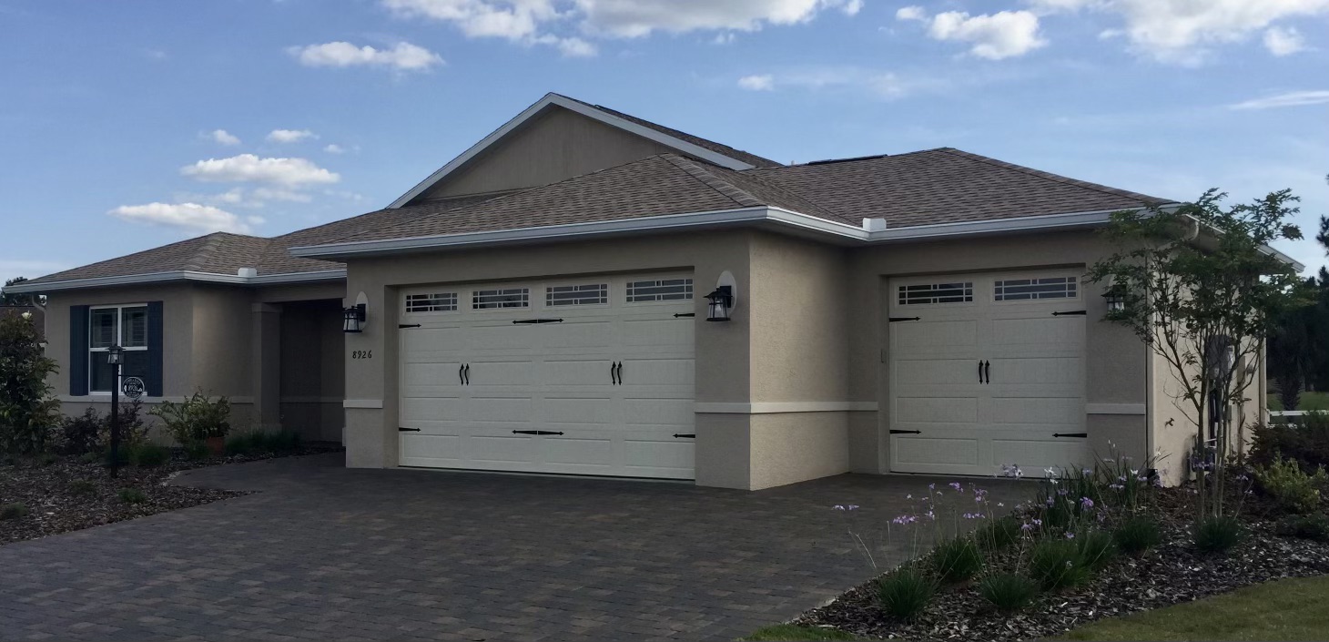 Stucco home with three-car garage and seamless gutters